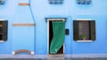 Bright light-blue house, colorful buildings on Burano island in Venice, tourism