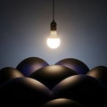 Contrast between the glowing bulb and the dark shapes suggesting a Royalty Free Stock Photo