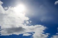 Bright light of the sun on a dark blue sky among the clouds Royalty Free Stock Photo