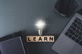 Bright lightbulb with LEARN wording with laptop and book. Growth idea of business working and education learning success.