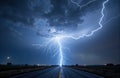Bright lightning bolt strikes across dark stormy sky over empty road at night Royalty Free Stock Photo