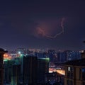 Bright lightning striking in the sky over a modern city during the nighttime