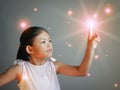 Bright lights coming out from little girl fingertip; Concept of childhood, imagination, creativity, happiness, dream, adventure,