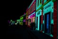 bright lights illuminate brightly colored buildings on an alley Royalty Free Stock Photo