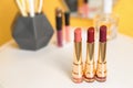 Bright lipsticks in gold tubes on dressing table Royalty Free Stock Photo