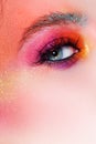 Bright makeup and face art, close-up of the eye. Bright pink eye shadow and glitter.