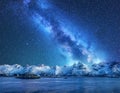 Bright Milky Way over snow covered mountains and sea at night