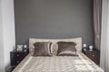 Bright, modern bedroom with beige bedspread. Royalty Free Stock Photo