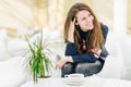 Young attractive woman with a cup of tea in a cafe.  Smiling, gap teeth. Royalty Free Stock Photo