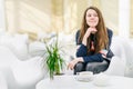 Young attractive woman with a cup of tea in a cafe. Smiling, gap teeth.