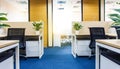 Bright and modern office space featuring cubicles with potted plants and light-filled windows Royalty Free Stock Photo