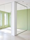 room corner featuring a large built-in wardrobe with mirrored doors reflecting the light green walls and windows Royalty Free Stock Photo