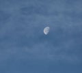 Bright moon in the clouded sky during the daylight