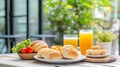 Bright Morning Breakfast Table Setting with Golden Pastries and Orange Juice Royalty Free Stock Photo