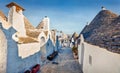 Bright morning view of empty strret with trullo trulli - traditional Apulian dry stone hut with a conical roof. Amazing summer