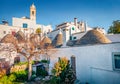 Bright morning view of trullo trulli houses - traditional Apulian dry stone hut with a conical roof. Royalty Free Stock Photo