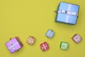 Bright multi-colored gift boxes tied with ribbons on a yellow background. 3D rendering Royalty Free Stock Photo