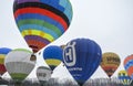 Bright multi-colored hot air balloons flying high in the sky during the aeronautic festival