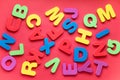 Bright multicolored alphabet background. Multicolored letters on red background. Flat Lay, top view Royalty Free Stock Photo