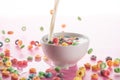 Bright multicolored breakfast cereal in bowl with pouring milk Royalty Free Stock Photo