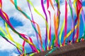 Bright multicolored ribbons on the wall develop against the sky, a view from below