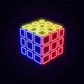 Bright neon sign in the form of a rubik`s cube, against the background of a brick wall.