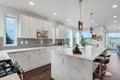 Bright and neutral kitchen with a large marble waterfall island