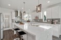 Bright and neutral kitchen with a large marble waterfall island