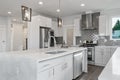 Bright and neutral kitchen with a large marble waterfall island