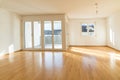 Bright new living room in an empty apartment with french doors and parquet wooden floors