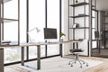 Bright office interior with book shelves, furniture, panoramic city view and empty mock up computer screen. Creative designer Royalty Free Stock Photo