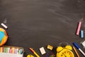 Bright office supplies, yellow alarm clock on black chalkboard top view, copy space. concept: back to school Royalty Free Stock Photo