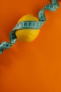 on a bright orange background, a blue sewing centimeter and various healthy vegetables arugula cucumbers lemon. for banners