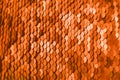 Bright orange background of sequins, shot closeup. Fashionable shade.