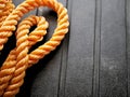 Bright orange braided nylon rope in tangled coil black background