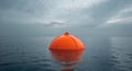 Bright Orange Buoy Floating On Open Sea With Overcast Sky. Royalty Free Stock Photo