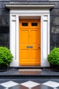 A bright orange door on a black and white checkered floor Royalty Free Stock Photo
