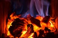 Bright orange embers with blue flames in wood stove