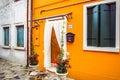 Bright orange facade of house with flowers in pots and white curtains in Venice, Italy Royalty Free Stock Photo