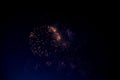 Bright orange fireworks and lots of blue and purple sparks on the background of the night sky Royalty Free Stock Photo
