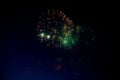 Bright orange fireworks and lots of green sparks on the background of the night sky Royalty Free Stock Photo