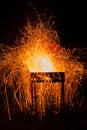 Bright orange flying sparks from barbecue in windy night