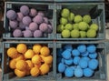 Bright orange, green, blue and purple effervescent bath balls in a wooden box on the market Royalty Free Stock Photo