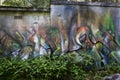Bright orange, green, blue and white abstract graffiti on a wall of an abandon building