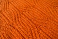 Bright orange handmade knit fabric with plait pattern