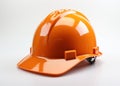 Bright orange hardhat placed on a clean white surface, construction and engineering image