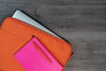 Bright orange laptop case with pink note book and pen flatlay Royalty Free Stock Photo