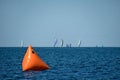 Orange sailboat race marker on lake