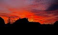 Bright orange red sunset with silhouettes of rural houses Royalty Free Stock Photo