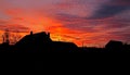 Bright orange red sunset with silhouettes of rural houses Royalty Free Stock Photo